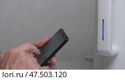 Man turns on kettle using an application on his smartphone. close-up. internet of Things - Home Wi-Fi management, devices and appliances with smartphone. smart home. Стоковое видео, видеограф ЛУНИНА ВЕРОНИКА / Фотобанк Лори