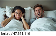 Woman annoyed by snoring partner in bedroom. Стоковое AI-изображение, AI-художник Андрей Бакусов / Фотобанк Лори