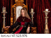 Regal Figure Exudes Elegance in a Majestic Indoor Setting Adorned With Rich Fabrics. Стоковое фото, фотограф Aleksandr Golubev / Фотобанк Лори
