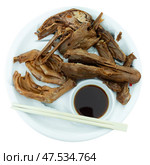 Portion of fried boiled parts of duck carcass is laid out on plate - paws, wings, head. Стоковое фото, фотограф Яков Филимонов / Фотобанк Лори