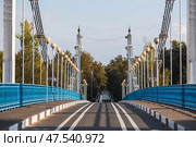 The bridge over the Kotorosl River to Damansky Island and people passing by. Yaroslavl, Russia. Редакционное фото, фотограф Photojuli / Фотобанк Лори