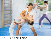 Woman and girl in gym perform basic elements of krav maga self-defense system. Стоковое фото, фотограф Яков Филимонов / Фотобанк Лори
