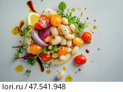 An artfully arranged deconstructed cannellini bean salad seen from above. The gourmet presentation highlights the salad's fresh ingredients against a neutral backdrop, perfect for culinary enthusiasts. Стоковое AI-изображение, AI-художник Nart / Фотобанк Лори