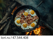 Savor a rustic farmhouse breakfast with crispy bacon and sunny-side-up eggs. A delicious top-down view captures the essence of hearty, home-cooked mornings. Стоковое AI-изображение, AI-художник Nart / Фотобанк Лори