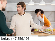 In home, male friends shake hands, say goodbye after socializing and gatherings. Стоковое фото, фотограф Яков Филимонов / Фотобанк Лори