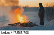 Lone man warming by bonfire in winter landscape at sunset. Стоковое AI-видео, аниматор Юрий Поздников / Фотобанк Лори