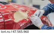 Auto body repairman removing putty from red car. Стоковое AI-видео, аниматор Юрий Поздников / Фотобанк Лори