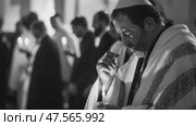 Jewish man praying with candle in synagogue during ceremony. Стоковое AI-видео, аниматор Юрий Поздников / Фотобанк Лори