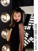Teen Girl in Elegant Fashion Pose With Vintage Flair Against Bright Lights. Стоковое фото, фотограф Aleksandr Golubev / Фотобанк Лори