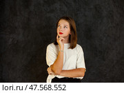 Thoughtful Teenage Girl Pondering Ideas Against a Dark Background With a Sense of Introspection. Стоковое фото, фотограф Aleksandr Golubev / Фотобанк Лори