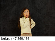 A Five-Year-Old Girl Stands Confidently With Her Hand on Her Chin, Pondering Something Intriguing. Стоковое фото, фотограф Aleksandr Golubev / Фотобанк Лори