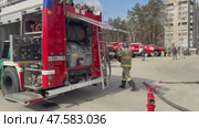 ANGARSK, IRKUTSK REGION, RUSSIA - April 08, 2025: Video of team of firefighters in special clothing and helmets equip a fire truck with hoses.  Firefighters preventive training. Редакционное видео, видеограф Виктория Катьянова / Фотобанк Лори