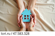 Family hands cradling a house cutout. Стоковое AI-изображение, AI-художник Андрей Бакусов / Фотобанк Лори