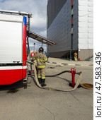 ANGARSK, IRKUTSK REGION, RUSSIA - April 08, 2025: Firefighter connected fire hose to street hydrant to extinguish a fire in a shopping center. Preventive training of firefighters. EMERCOM of Russia. Редакционное фото, фотограф Виктория Катьянова / Фотобанк Лори