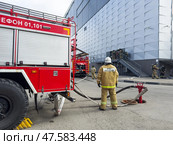ANGARSK, IRKUTSK REGION, RUSSIA - April 08, 2025: Team of firefighters enters building to put out fire. Fire hose is connected to hydrant. Firefighters preventive training. Russian EMERCOM. Редакционное фото, фотограф Виктория Катьянова / Фотобанк Лори