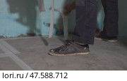 Grouting of joints between ceramic tiles. Cleaning after renovation. Construction. The adhesive tape is removed from the floor. Стоковое видео, видеограф Darya Komarova / Фотобанк Лори