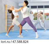 Woman and girl in gym perform basic elements of krav maga self-defense system. Стоковое фото, фотограф Яков Филимонов / Фотобанк Лори