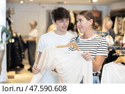 Young couple choosing convenient jumper in clothing store. Стоковое фото, фотограф Яков Филимонов / Фотобанк Лори