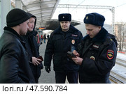 Полицейские проверяют документы у гражданина по переносному компьютеру. Москва (2017 год). Редакционное фото, фотограф Free Wind / Фотобанк Лори