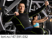 Smiling man performing chest press in exercise machine. Стоковое фото, фотограф Яков Филимонов / Фотобанк Лори