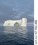 A huge high breakaway glacier drifts in the southern ocean off the coast of Antarctica at sunset, the Antarctic Peninsula, the Southern Arctic Circle, azure water, cloudy weather. Стоковое фото, фотограф Vladimir Drozdin / Фотобанк Лори
