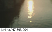The warm golden sunlight reflects on the rippling waters of the Vltava River, creating a dreamy and serene scene. Стоковое видео, видеограф Igor Tichonow / Фотобанк Лори