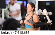 Woman is concentrating on doing hand exercises on a simulator. Client of the gym does shoulder extensions for the deltoid muscle. Exercises for strength and relief of the arms. Стоковое видео, видеограф Яков Филимонов / Фотобанк Лори