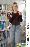 Smiling young woman customer deciding on nail polish in beauty department at store. Стоковое видео, видеограф Яков Филимонов / Фотобанк Лори