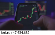 Close-up of trader using trading app on smartphone. Стоковое видео, видеограф Arsenii Palivoda / Фотобанк Лори