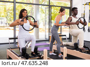 Healthcare professional helps an man restore health with gymnastic ring in pilates class. Стоковое фото, фотограф Яков Филимонов / Фотобанк Лори