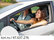 Cheerful girl driving car with boyfriend in passenger seat. Стоковое фото, фотограф Яков Филимонов / Фотобанк Лори