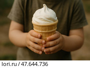 Мороженое. Руки ребенка держат рожок с пломбиром на улице. Стоковое AI-изображение, AI-художник Башкирова Анна / Фотобанк Лори