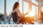 Inner Strength: A woman in a wheelchair embraces hope at sunrise, finding peace and envisioning a brighter future. Стоковое AI-изображение, AI-художник Данила Большаков / Фотобанк Лори