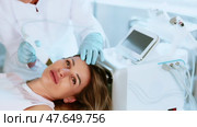 Interested young female patient undergoing facial skin cleansing with ultrasonic shovel to enhance efficacy of skincare products and improving skin texture. Modern hardware cosmetology. Стоковое видео, видеограф Яков Филимонов / Фотобанк Лори