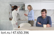 Man was sad because women were arguing in his presence in kitchen. Стоковое видео, видеограф Яков Филимонов / Фотобанк Лори