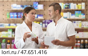 Man client with prescription should contact girl pharmacist for help, takes box remedy. Стоковое видео, видеограф Яков Филимонов / Фотобанк Лори