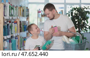 Dad and son filled shopping basket with household purchases, looking for missing items in window. Стоковое видео, видеограф Яков Филимонов / Фотобанк Лори