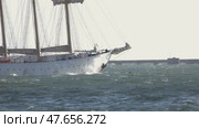 Large white sailing ship navigating rough sea near harbor wall. Стоковое видео, видеограф Константин Шишкин / Фотобанк Лори
