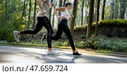 Wide angle shot of a couple running in the forest trail. Intentional motion blur. Focus on feet. Side view. Стоковое AI-изображение, AI-художник Катерина Ковалева / Фотобанк Лори