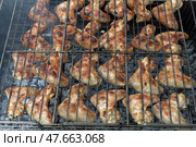 Маринованные куриные крылышки на решетке, приготовление на мангале - Marinated chicken wings on the grill, cooking on the grill. Стоковое фото, фотограф Владислав Дельдюгинов / Фотобанк Лори