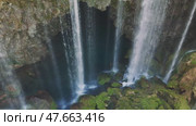Cascading waterfall plummeting from jagged rocky cliff into verdant basin, surrounded by lush greenery in scenic turkish wilderness. Стоковое видео, видеограф ILIA GOROKHOV / Фотобанк Лори