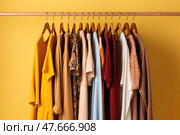 Wooden hangers with clothes on the rail in the store with women's clothing for sale. Flea market, second hand, discount, exchange, donation. Стоковое AI-изображение, AI-художник Оксана Гильман / Фотобанк Лори