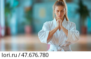 Martial Arts: Tranquil female athlete in a karate gi meditating for inner peace. Стоковое AI-изображение, AI-художник Данила Большаков / Фотобанк Лори