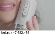 The woman shows her dazzling smile, achieved through regular use of a dental irrigator. Easy and effective dental care. Стоковое видео, видеограф Svetlana Golovco / Фотобанк Лори
