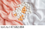 Wellness concept: Arrangement of pharmaceutical tablets on soft fabric, medication for health, vitamins, supplements for wellbeing. Стоковое AI-изображение, AI-художник Данила Большаков / Фотобанк Лори