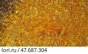 Yellow natural moving background. The process of overcooking carrots in vegetable oil. Bubbles of boiling oil swell and collapse. Стоковое видео, видеограф Константин Мерцалов / Фотобанк Лори
