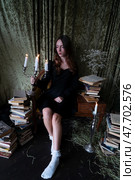 An Enchanting Sorceress is deeply engrossed in reading a Spellbook surrounded by swirling, Mystical Smoke. Стоковое фото, фотограф Anastasy Yarmolovich / Фотобанк Лори