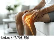Modern medical image showing a male knee with a visualization of the joint anatomy as a digital graphic. The man is sitting on a couch, supporting his knee with his hands, which may indicate pain, discomfort or joint problems. The background is a light, blurry interior, creating a neutral, calming atmosphere. The illustration is ideal for use in the following topics: orthopedics, joint health, physical therapy, sports medicine, arthritis, rehabilitation and medical technology. Стоковое AI-изображение, AI-художник Анна Кривицкая / Фотобанк Лори