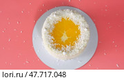 Cake with orange and coconut shavings spun on a pink background. Стоковое видео, видеограф Mikhail Davidovich / Фотобанк Лори