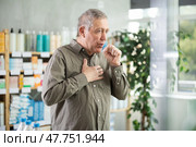Senior man visits pharmacy and suffers from cough. Стоковое фото, фотограф Яков Филимонов / Фотобанк Лори